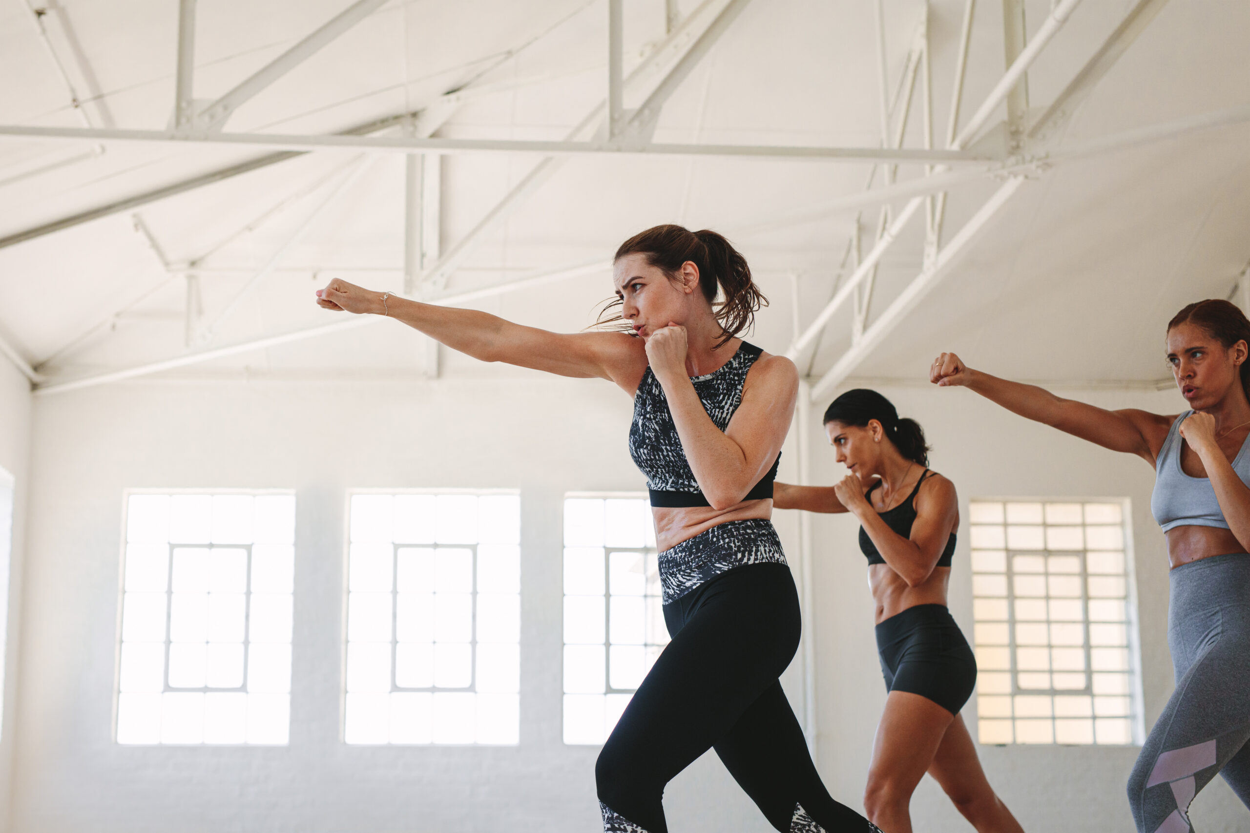 Athletic women working out at a fitness studio. Fitness women doing punching exercises.