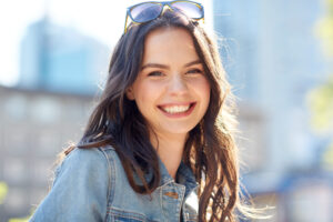 women and people concept - happy smiling young woman on summer city street